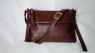 sac besace en cuir marron avec un pompon et une bandoulière