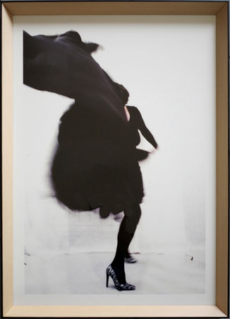 Letizia Rostagno, Il mio nome è notte #4, 2025. Figura in trasformazione avvolta in un panneggio nero in movimento dinamico, corpo nascosto, visibili gambe in calze nere e tacco a stiletto. Stampa digitale su Canson Platine Fibre, cm 48×34, cornice in leg