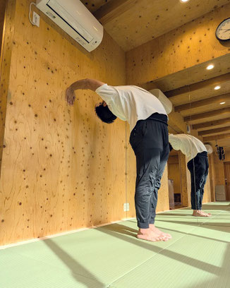 身体を後方へ反らし、後ろが見えて、壁に手がつけられる。