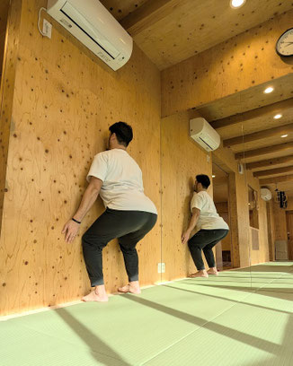 つま先を壁に付けた状態で、胸を張ったままある程度しゃがめる。
