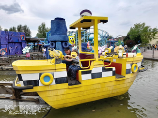Frau mit Kind in einem gelben Boot auf einer Wasserbahn im Movie Park Bottrop.