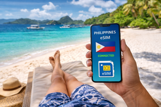 Tourist schaut auf Handy mit E-Sim am philippinischen Traumstrand