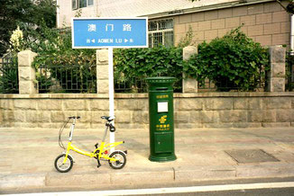 mein gelbes Mini-Bike neben der grünen Postbox-Säule