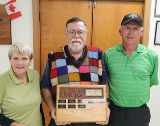 Photo of tournament winners MaryLou Demers and Dave Austen with sponsor Martin Henly and tournament trophy.