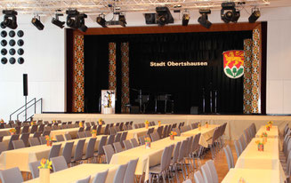 Foto Bühnenblick mit Tischreihen und Stühlen