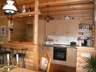 Eine offene Küche mit Theke im Holzhaus in massiver Blockbauweise