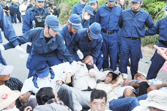 ヘリパッド工事現場周辺で機動隊に排除される反対派=22日午前