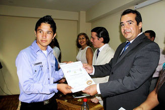 Un joven morador barrial recibe el certificado de haber participado en un curso sobre uso de las TIC. Chone, Ecuador.