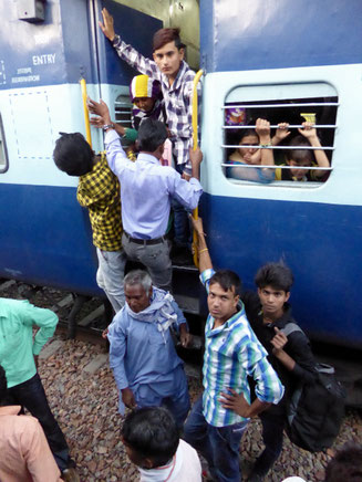 Bild: Menschen in Indien steigen in einen Zug