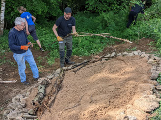 Umrandet mit Feldsteinen und Totholz