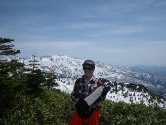 釈迦岳山頂。転がっていた道標を抱えてやたら嬉しそう。背景は別山。