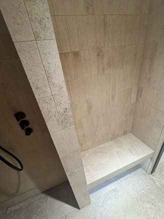 Douche réalisée en plaquettes de pierres naturelles françaises, avec banc et sol