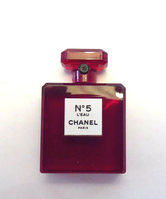REPLIQUE EN PLASTIQUE ROUGE AYANT LA FORME D'UNE MINIATURE - CELLE-CI NE CONTIENT PAS DE PARFUM. DANS LA REALITE, IL EXISTE BIEN UNE MINIATURE ROUGE.