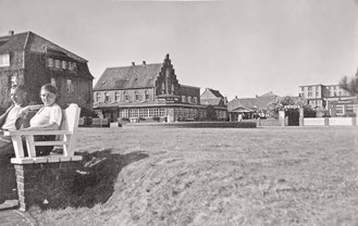 1930 Auf einer der wunderbaren alten Bänke in der Mittagssonne auf dem heutigen Kurplatz. Im Hintergrund noch ein Direktzugang zum Hotel Worch .