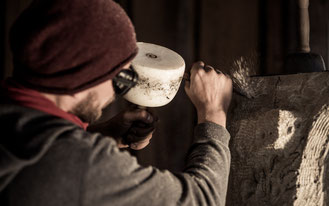 Steinmetz Marcus Scheffczyk bearbeitet Sandstein mit einem Zahneisen
