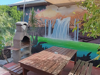 Private terrace, bungalow No.7 – outdoor dining area, table and benches, private BBQ, mural