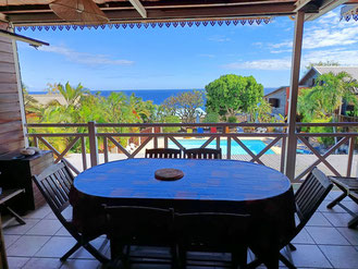 Terrasse privative bungalow n°9 – coin repas, table et chaises, barbecue privatif, vue panoramique sur la mer
