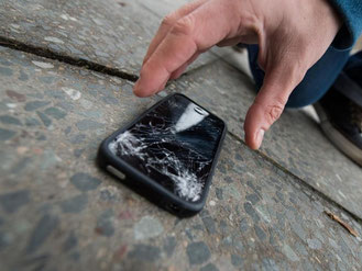 Ein Sturz auf den Asphalt - schon ist das Display kaputt. Wer ein Smartphone zur Reparatur bringt, muss oft lange warten und viel bezahlen. Zu dem Ergebnis kommt Stiftung Warentest. Foto: Franziska Gabbert