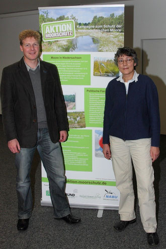 Referent Dr. Holger Buschmann, NABU, und Moderatorin Susanne Grube, Schutzgemeinschaft ländlicher Raum Nord-West, vor der Infotafel der "Aktion Moorschutz" (Foto: Silke Lorenz)