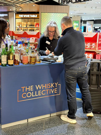 Sigrid Bengel graviert live eine Whiskyflasche für einen Kunden am Whisky Collective Stand, Flughafen Zürich 2026