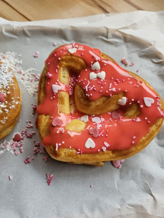 Gefüllte Windbeutel-Herzen mit rotem Zuckerguss