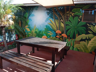 Private terrace, bungalow No.6 – outdoor dining area, table, private BBQ, tropical mural