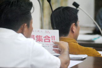 集会参加を呼び掛けるビラを手に市当局を追及する仲嶺氏(18日)