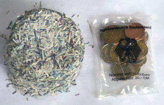 Ein Haufen klein geschredderter DM-Scheine und das Startpaket der Bundesbank mit Euromünzen im Wert von 10,23 €, das waren genau 20 DM“