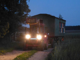 Der Traktor zieht den Bienenwagen an den neuen Standort in die Robinie