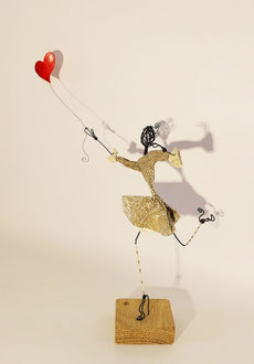 sculpture personnage féminin en équilibre avec coeur