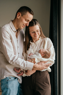 papa en mama houden samen de baby vast en kijken naar hun slapende kindje-babyreportage-newbornfotograaf-Fotografils-by Ilse Wagemakers-fotograaf Essen