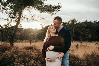 portret van zwanger koppel bij golden hour, met op de achtergrond de ondergaande zon, in de Kalmthoutse Heide-zwangerschapsfotografie-©Fotografils-byIlseWagemakers-fotograaf-based in Essen, België