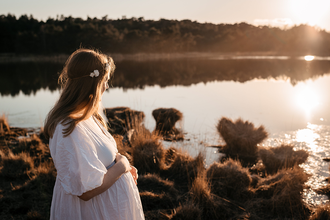 portret van zwangere vrouw turend over het Putse Moer bij zonsondergang-zwangerschapsfotografie-©Fotografils-byIlseWagemakers-fotograaf-basedinEssen