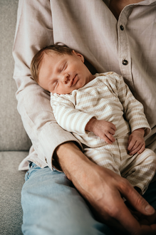 baby ligt glimlachend te slapen op de arm van papa-babyreportage-newbornfotografie-Fotografils-by Ilse Wagemakers-fotograaf Essen
