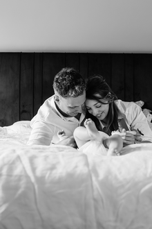 portret van papa en mama, liggend op bed met hun baby-babyreportage-newbornfotografie-Fotografils-by Ilse Wagemakers-fotograaf Essen