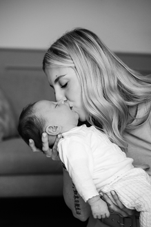mama houdt baby voor zich en geeft hem een zoentje-babyreportage-newbornfotografie-Fotografils-by Ilse Wagemakers-fotograaf Essen