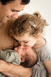 papa met baby op de arm en peuterdochter geeft terwijl een zoentje aan haar babybroertje-babyreportage-newbornfotografie-Fotografils-by Ilse Wagemakers-fotograaf Essen