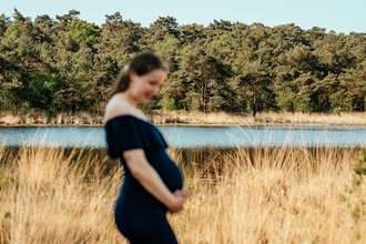 portret van zwangere vrouw bij het Putse Moer, waarbij de Putse Moer in focus is-zwangerschapsfotografie-©Fotografils-byIlseWagemakers-fotograaf-basedinEssen