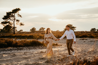 zwanger koppel hand in hand rennend door de Kalmthoutse heide bij golden hour-zwangerschapsfotografie-©Fotografils-byIlseWagemakers-fotograaf-basedinEssen