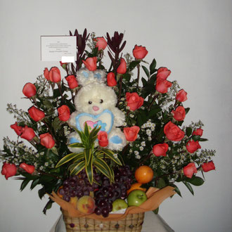 REF.28 ARREGLO EN ROSAS DE COLOR SALMÓN ,PROTEAS, PELUCHE Y FRUTAS ELABORADO SOBRE CANASTA TEJIDA A AMONO.