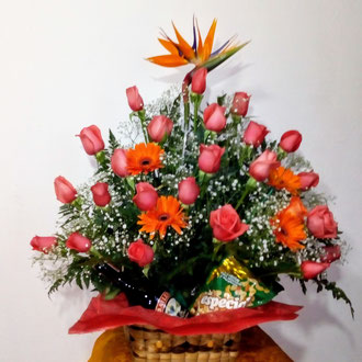 REF. 69 ARREGLO EN ROSAS DE COLOR SALMON,AVE DEL PARAÍSO,GERBERAS, BOTELLA DE CREMA  Y MANI ELABORADO SOBRE CANASTA TEJIDA A MANO.