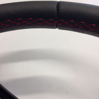 Détail volant Nissan Skyline cuir grainé noir, point losange, fil rouge