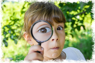 Mädchen schaut durch eine Lupe