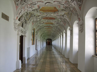 Weiß gehaltener Gang mit verzierter Stuckdecke im Kloster Wessobrunn