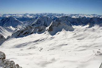 Blick von der Zugspitze auf verschneite Berggipfel bei strahlend blauem Himmel