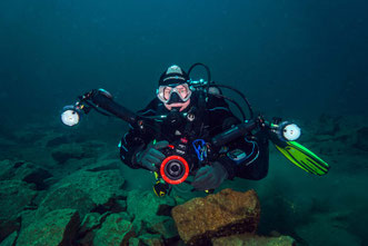 Taucher mit Fotoequipment unter Wasser