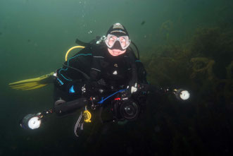 Taucher mit Fotoequipment unter Wasser