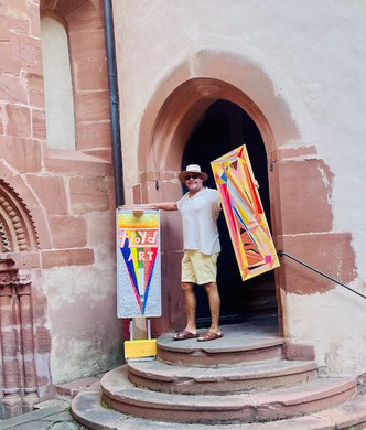 Andreas Alka alias FLoYd mit abstrakten Kunstinstallationen vor der historischen Schlosskapelle Büdingen. Farbenreiche Werke im Aufbau zur Landpartie-Ausstellung.