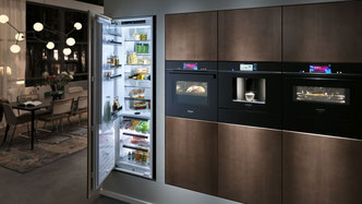 Einbaugeräte von Siemens – elegante Studioline-Küche mit Backofen, Kaffeemaschine, Dampfbackofen und integriertem Kühlschrank.