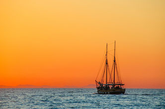 ein Segelboot am blauen Meer im Sonnenuntergang